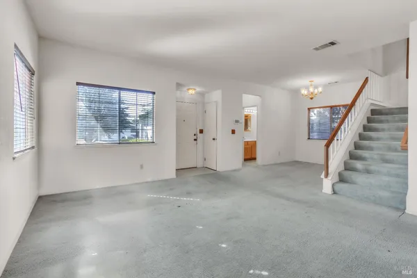 an empty room with windows and stairs