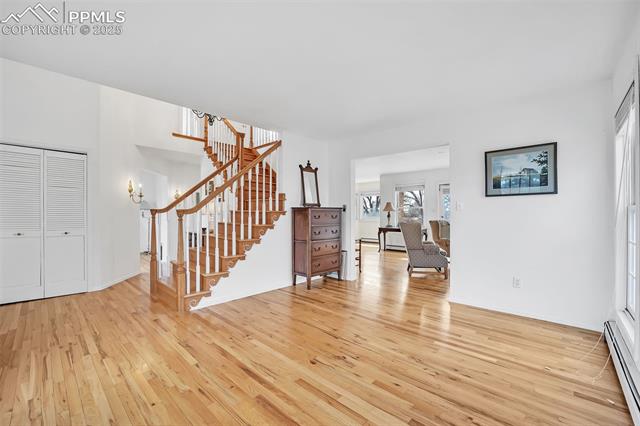 3954 County Rd KK 75 Fowler, CO 81039 - Photo 10 of 41 Unfurnished living room featuring a baseboard heating unit, light wood-style floors, and stairs