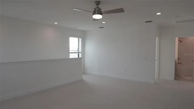 an empty room with closet and windows