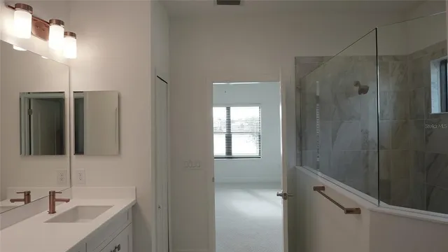 a bathroom with a shower sink and mirror