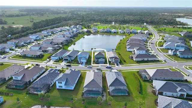 an aerial view of residential houses with outdoor space and lake view