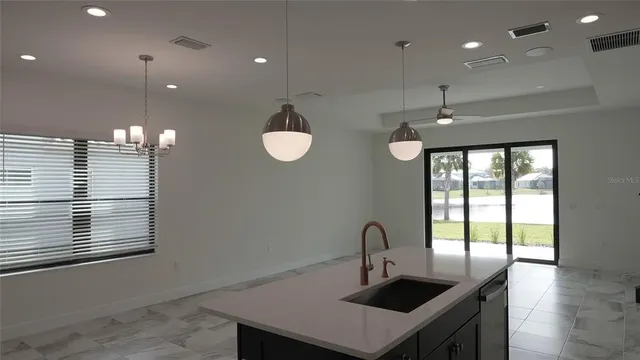 a kitchen with stainless steel appliances granite countertop a sink a stove and a wooden floors