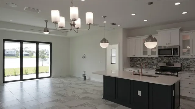 a large kitchen with kitchen island granite countertop a sink and a cabinets