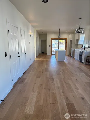 a view of a kitchen with wooden floor and a window