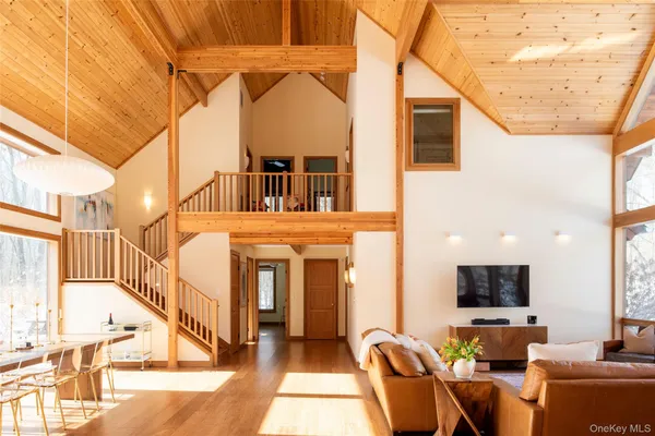 a living room with furniture a flat screen tv and entryway