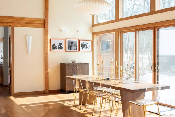 a dining room with furniture and large windows