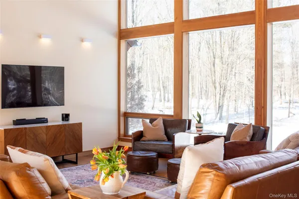 a living room with furniture and floor to ceiling windows