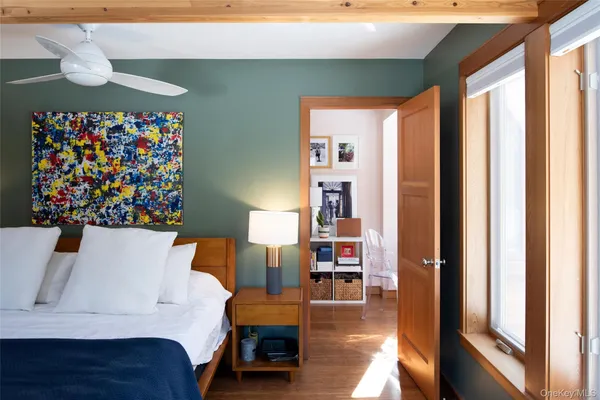 a bedroom with a bed and a painting on the wall