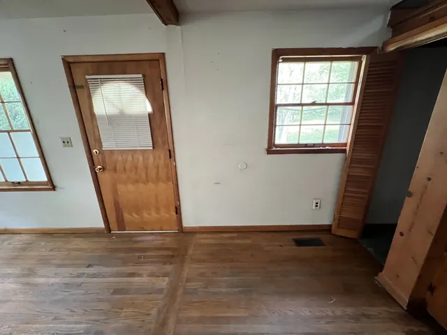 an empty room with wooden floor and a window