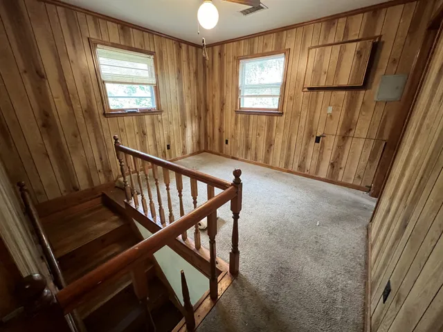 a view of a hallway with wooden floor and staircase