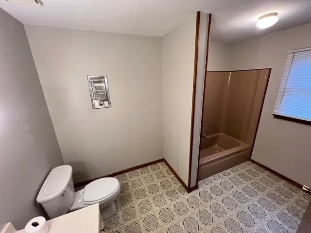 a bathroom with a toilet and a shower