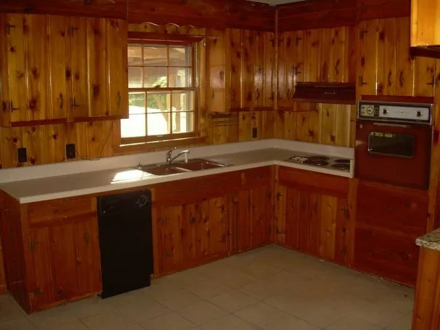a kitchen with stainless steel appliances granite countertop wooden cabinets and a sink