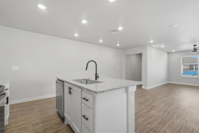 a kitchen with a sink and wooden floor