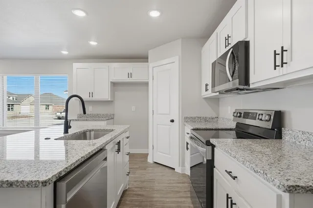 a kitchen with granite countertop a sink and a stove top oven