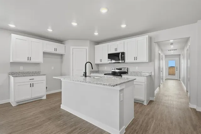 a kitchen with appliances a sink and cabinets