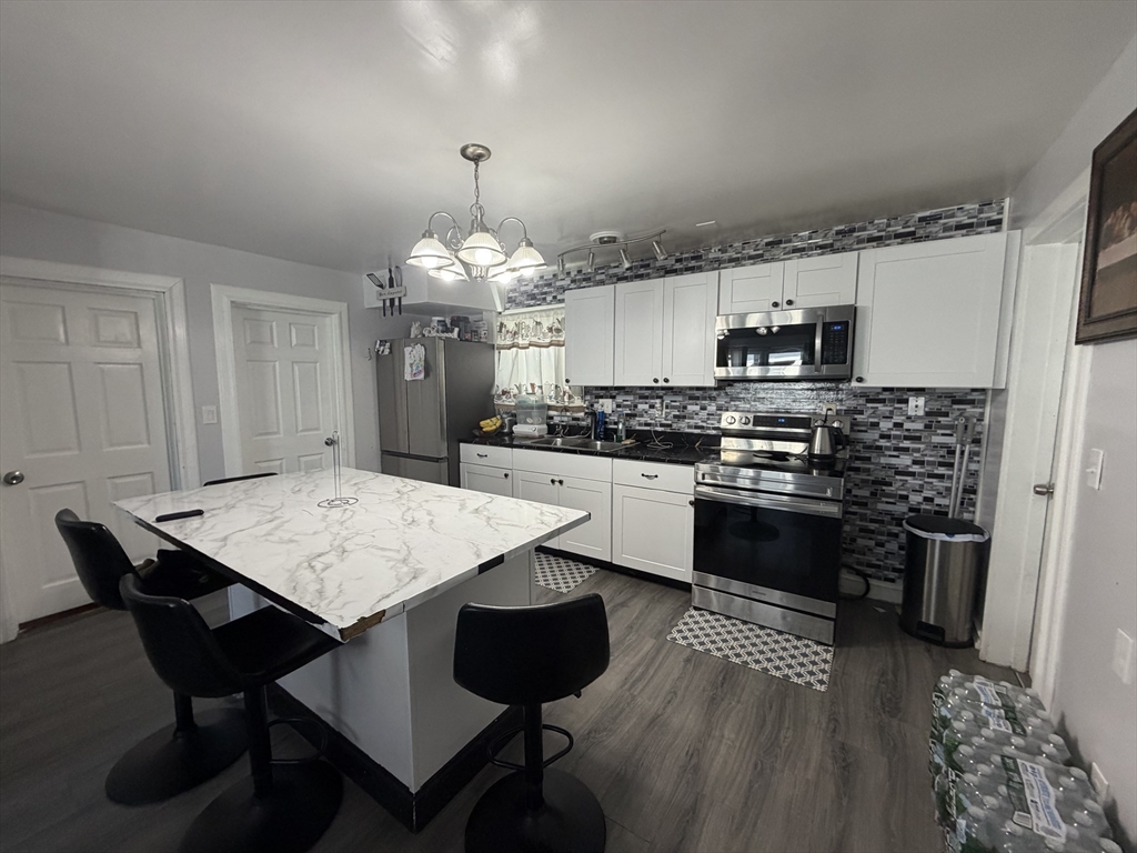 28-32 Chester Street Lawrence, MA 01843 - Photo 3 of 30 a kitchen with a dining table chairs and refrigerator