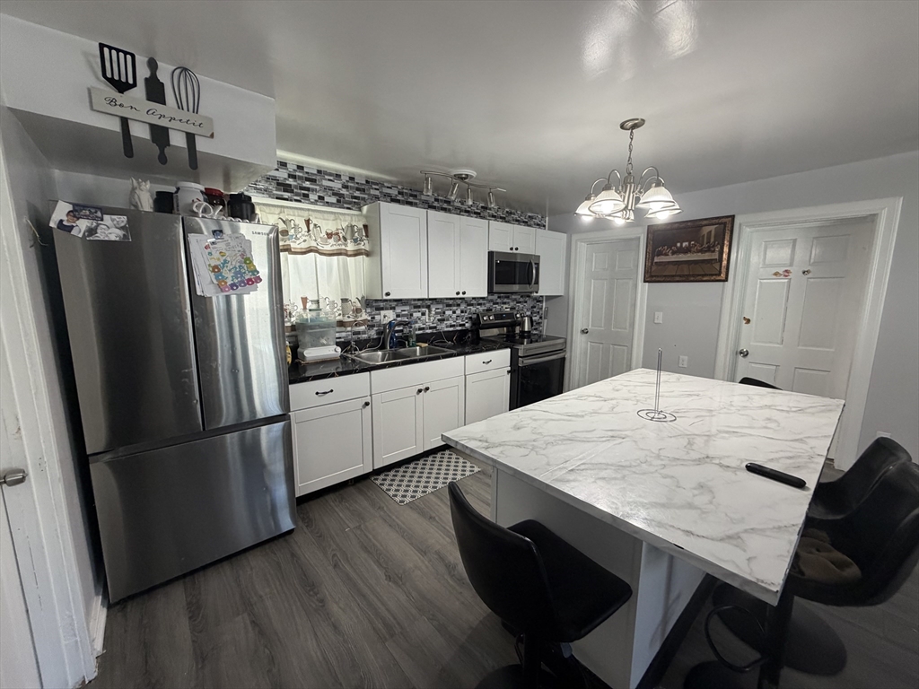 28-32 Chester Street Lawrence, MA 01843 - Photo 4 of 30 a kitchen with stainless steel appliances a dining table and refrigerator