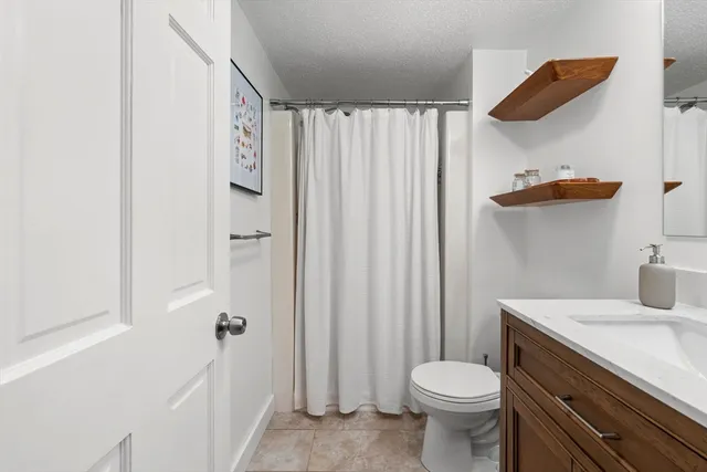 a bedroom with a bed and painting on the wall