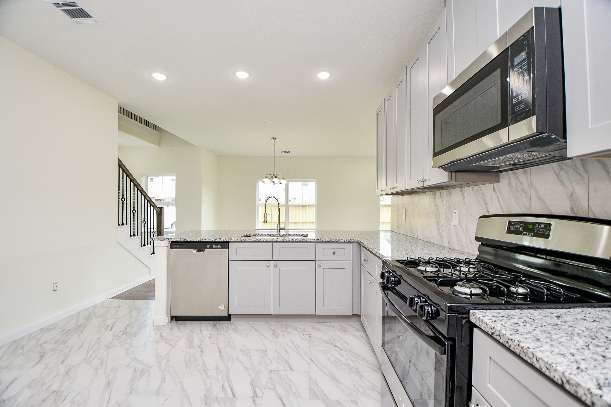2803 Bowlin Leaf Lane Houston, TX 77014 - Photo 12 of 28 a kitchen with stainless steel appliances granite countertop a stove a sink and a microwave