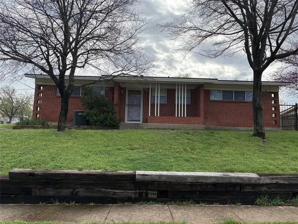 a view of a house with a yard and a large tree