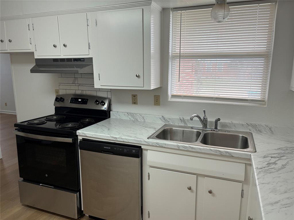 3601 Slade Boulevard Fort Worth, TX 76116 - Photo 13 of 14 a kitchen with white cabinets and a stove top oven