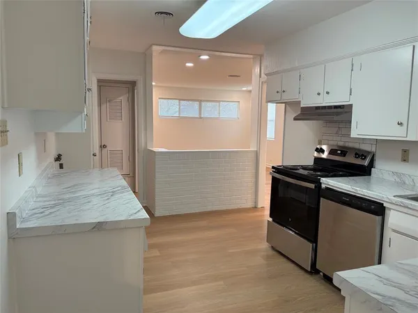 a kitchen with kitchen island stainless steel appliances a sink stove and cabinets
