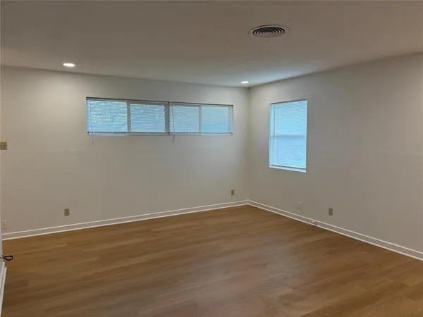 a view of a room with wooden floor and window