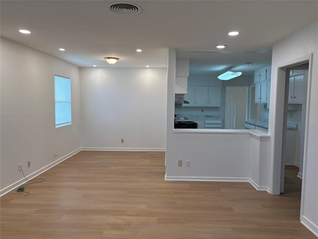 3601 Slade Boulevard Fort Worth, TX 76116 - Photo 7 of 14 an empty room with wooden floor and windows