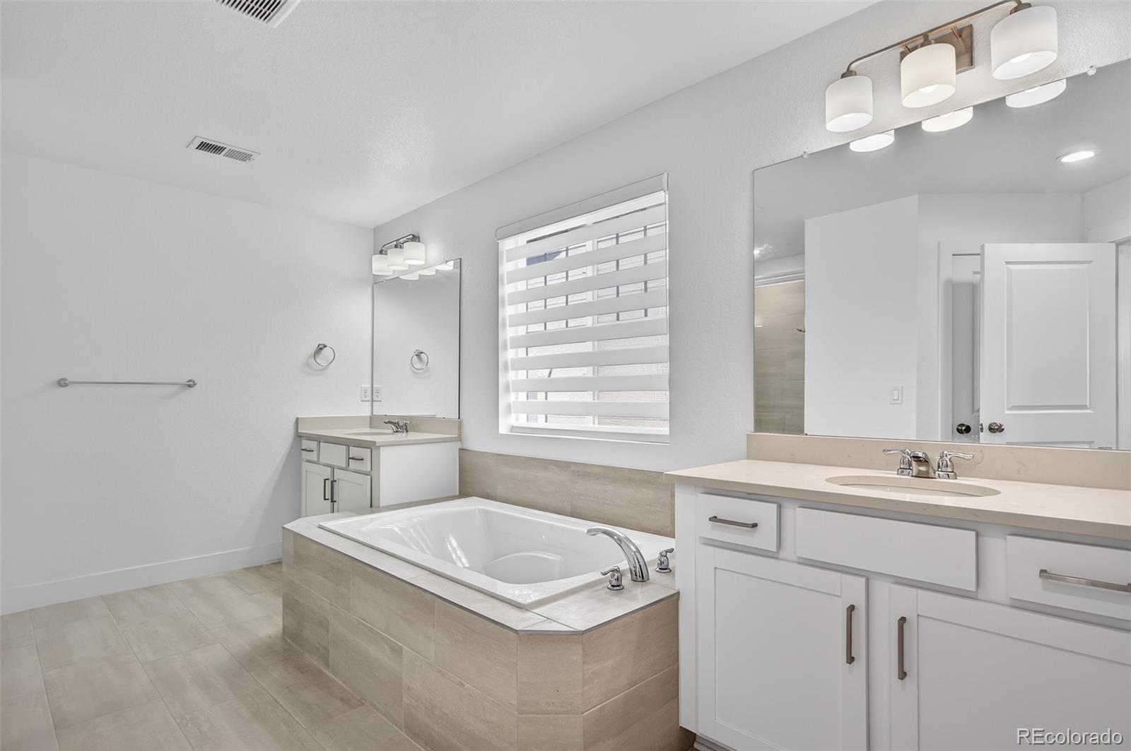 3649 Rucksack Court Castle Rock, CO 80108 - Photo 27 of 48 a bathroom with a tub a sink and mirror