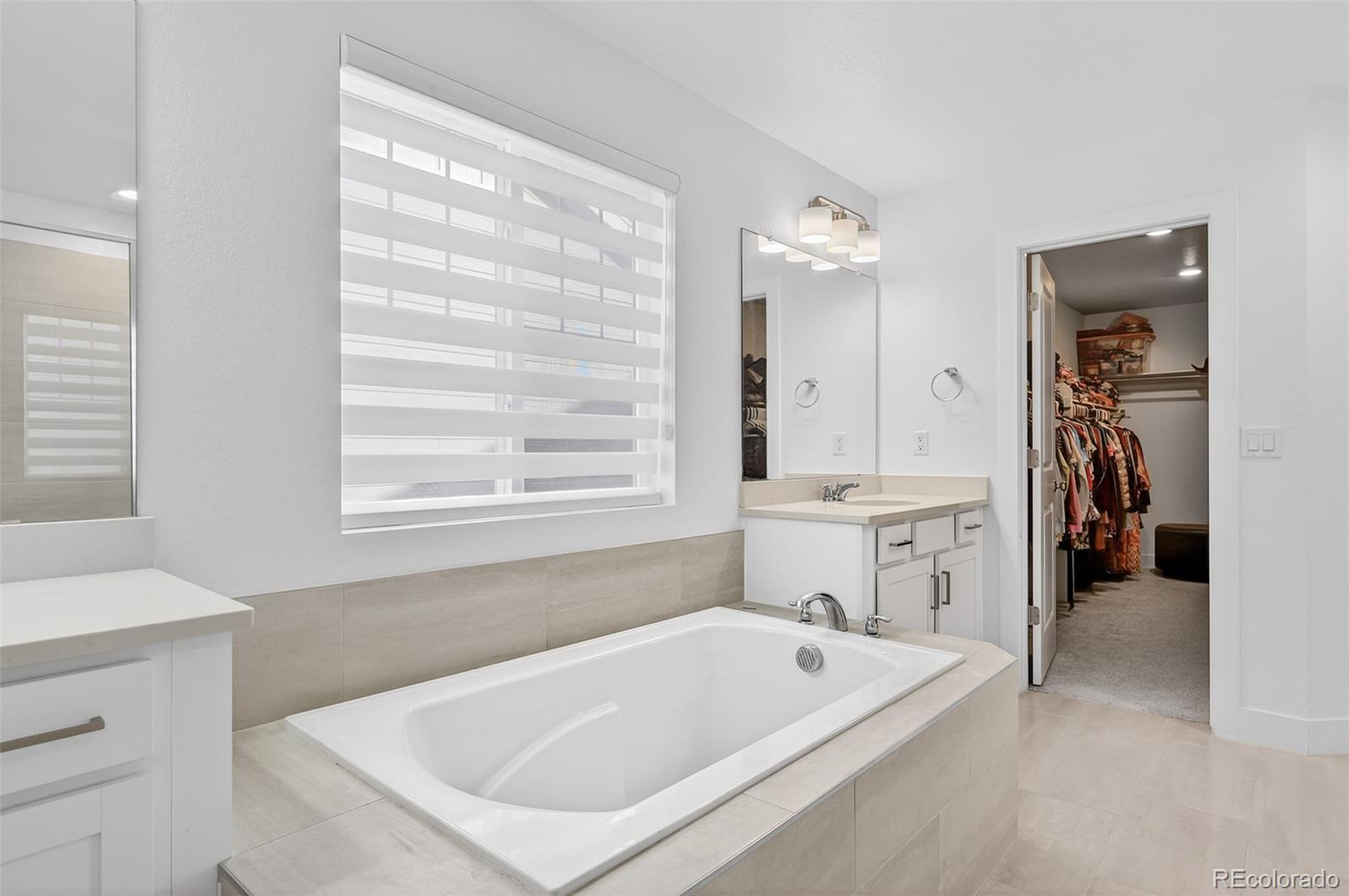3649 Rucksack Court Castle Rock, CO 80108 - Photo 28 of 48 a bathroom with a tub a sink and a window