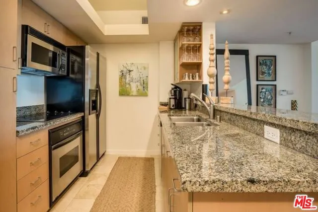 a kitchen with kitchen island granite countertop a stove and a sink