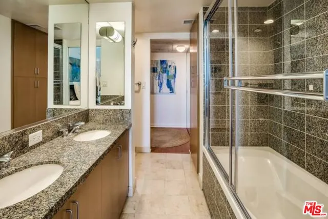 a bathroom with a granite countertop sink and a bathtub
