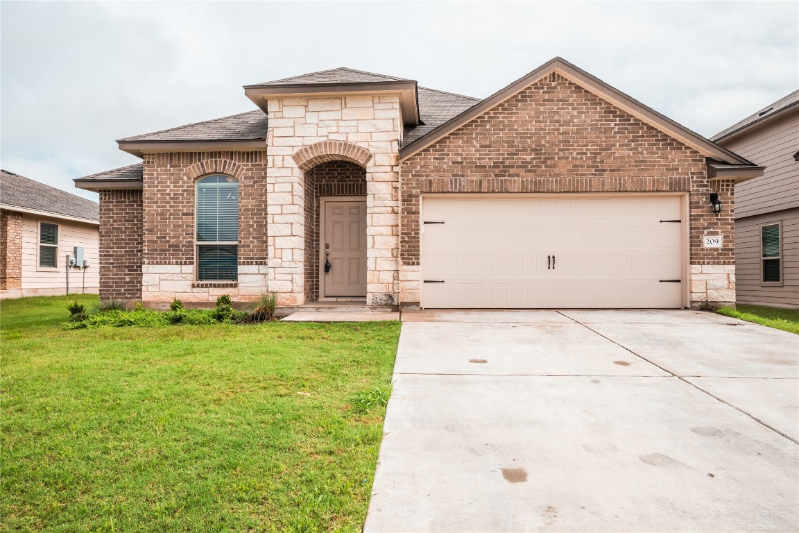 209 Reagor Drive Taylor, TX 76574 - Photo 1 of 1 a front view of a house with garden