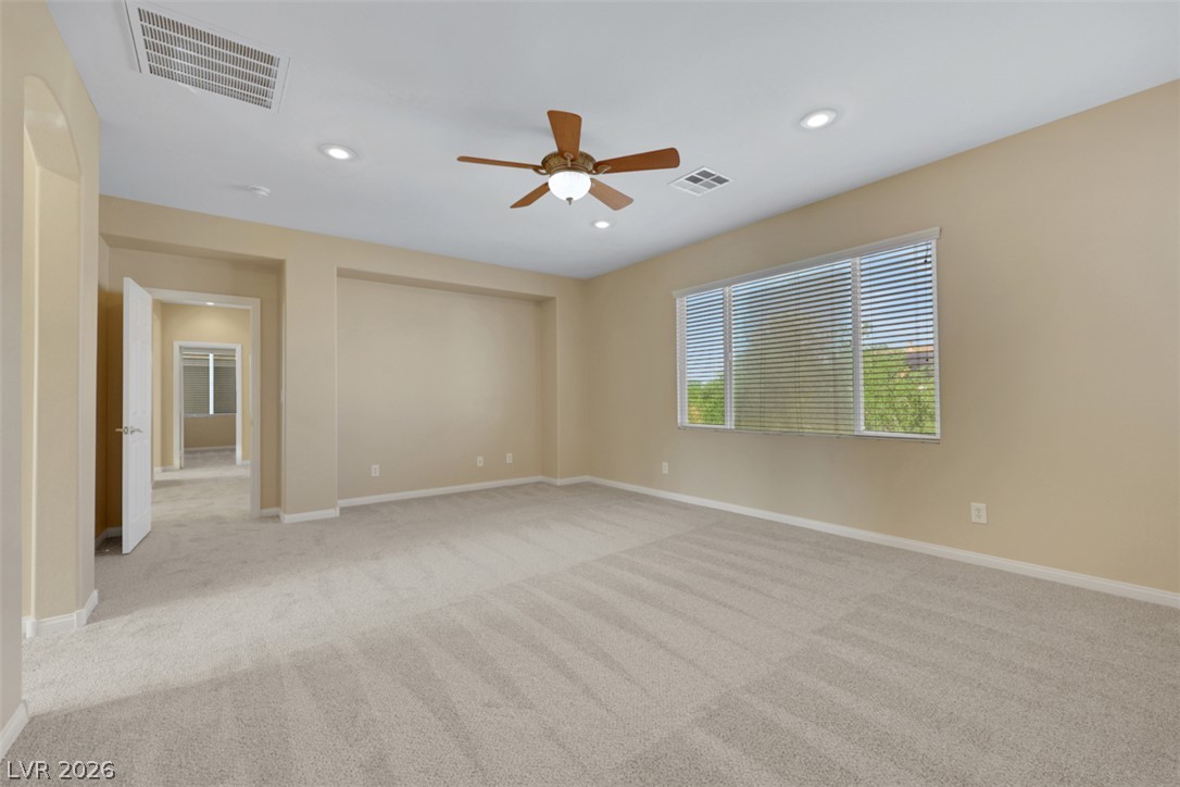 10328 Hawk Ravine Street Las Vegas, NV 89178 - Photo 40 of 55 A spacious bedroom featuring neutral tones and ample natural light, ready for personalization.