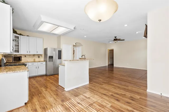 a kitchen with cabinets and wooden floor