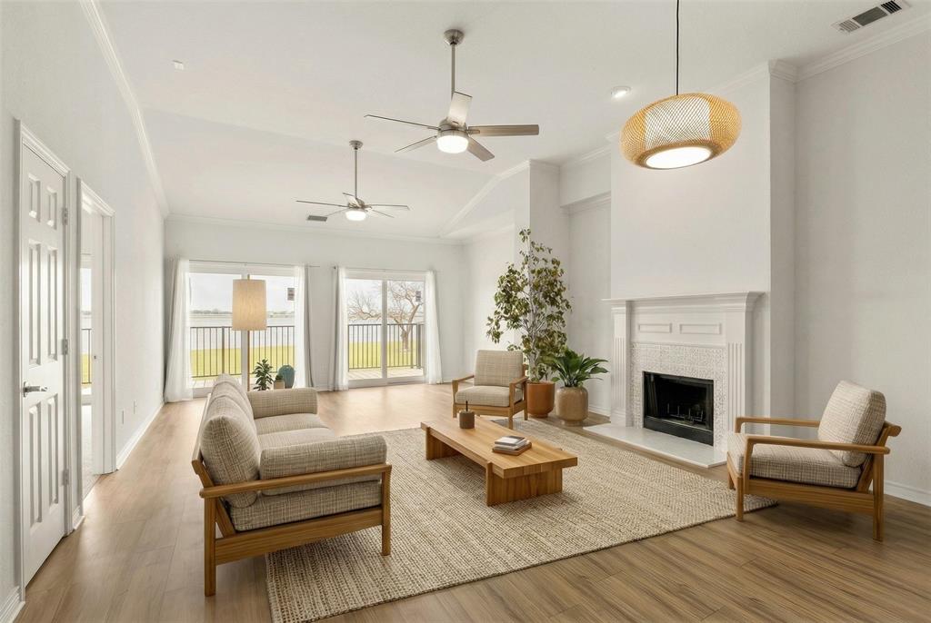 1916 Signal Ridge Place Rockwall, TX 75032 - Photo 1 of 32 Virtually staged Living room with ornamental molding, a fireplace with raised hearth, light wood-style floors, a ceiling fan, and lofted ceiling