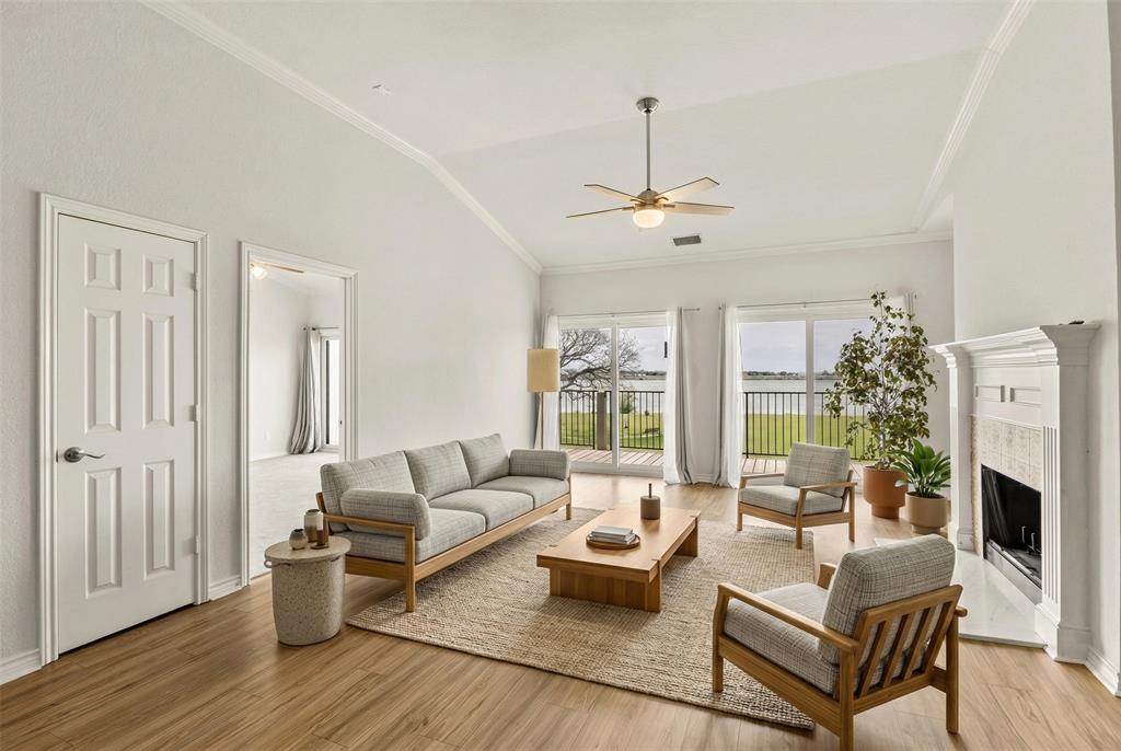1916 Signal Ridge Place Rockwall, TX 75032 - Photo 11 of 32 Virtually staged Living area with ornamental molding, vaulted ceiling, ceiling fan, light wood-type flooring, and a tile fireplace