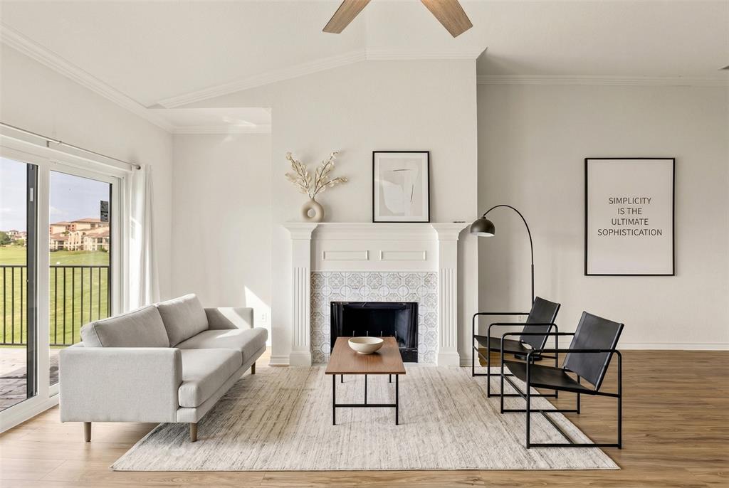 1916 Signal Ridge Place Rockwall, TX 75032 - Photo 3 of 32 Virtually staged Living area with vaulted ceiling, light wood-style floors, crown molding, a fireplace, and a ceiling fan