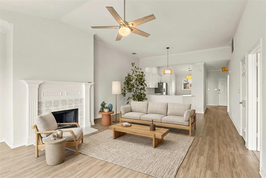 1916 Signal Ridge Place Rockwall, TX 75032 - Photo 5 of 32 Virtually staged Living room featuring a ceiling fan, crown molding, light wood-type flooring, a tile fireplace, and vaulted ceiling