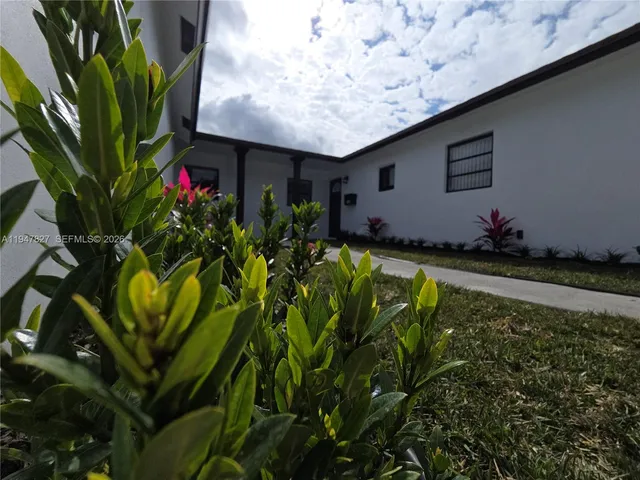 a vase of flowers sitting in front of a house