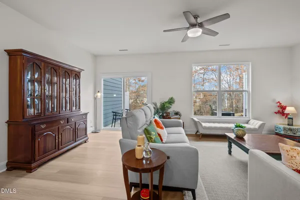 a view of a hallway with wooden floor and chandelier fan