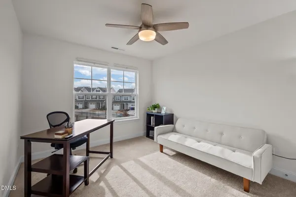a view of a room with a hanging light and hardwood floor