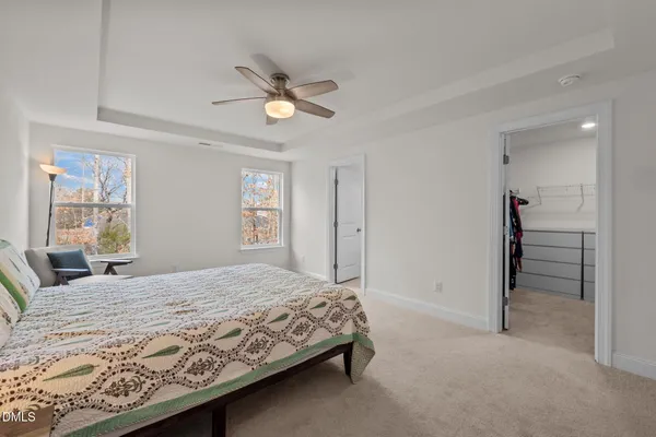 a bedroom with a bed a chair and a chandelier