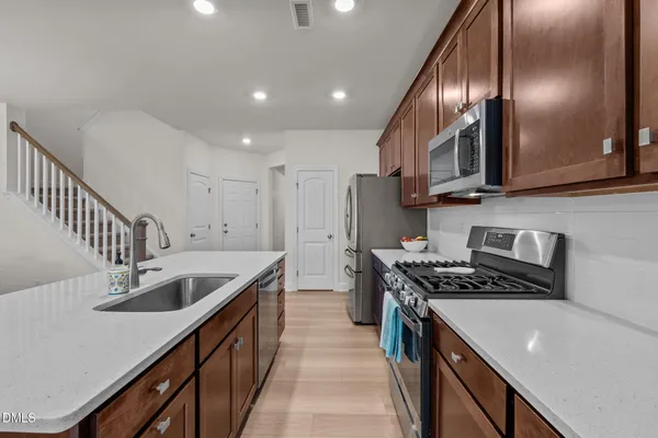 a kitchen with stainless steel appliances granite countertop a refrigerator and a stove