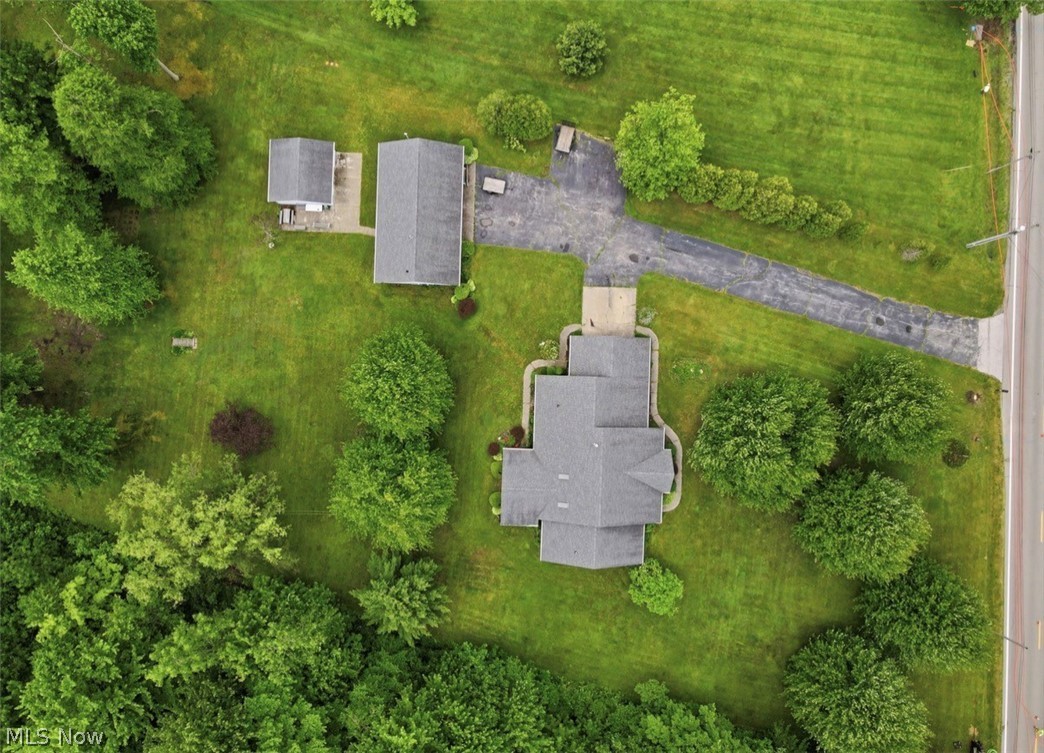 3556 Lake Road Conneaut, OH 44030 - Photo 38 of 39 Expansive property featuring a main residence with a gray shingle roof, a detached garage with a gray shingle roof, a separate accessory structure, a paved driveway, and mature landscaping