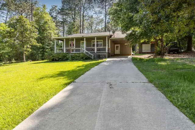 front view of a house with a yard and potted plants