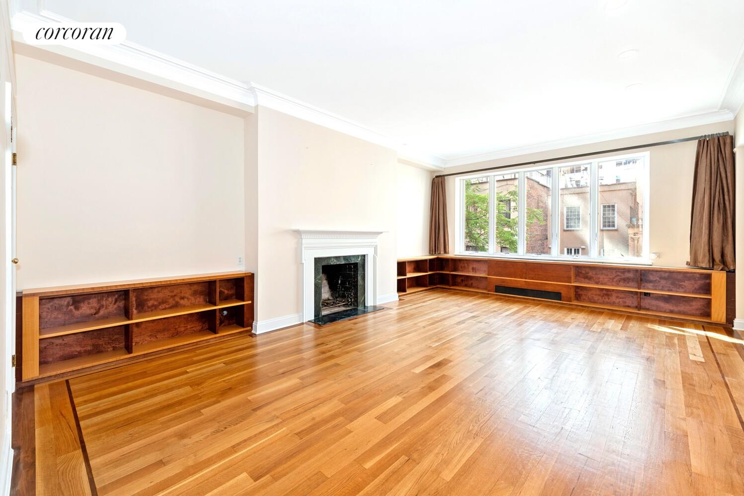 16 East 84th Street, Unit 4AB Manhattan, NY 10028 - Photo 2 of 14 a view of empty room with wooden floor and fireplace