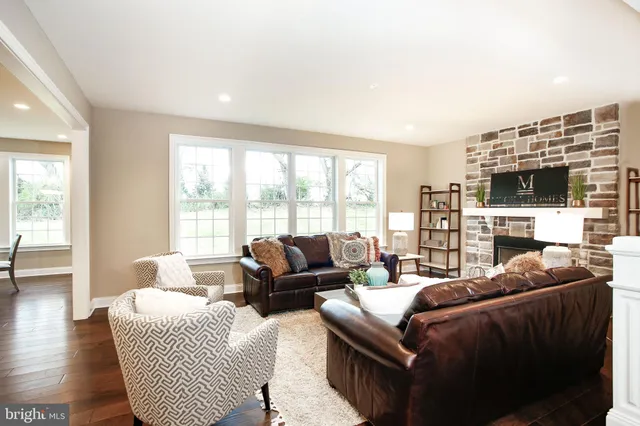 a living room with furniture a flat screen tv and a large window