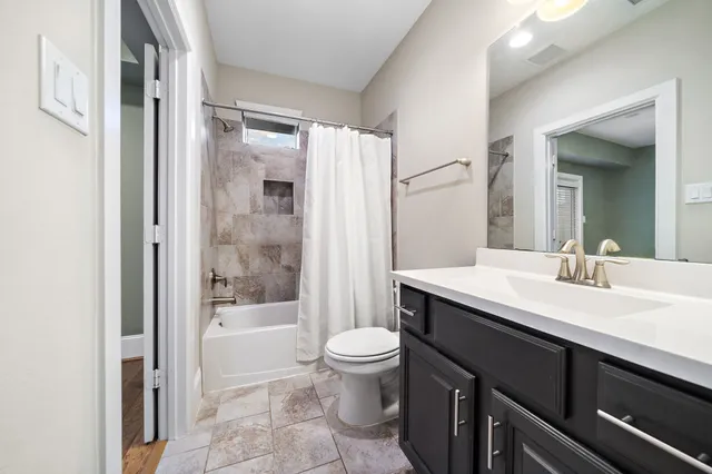 a bathroom with a sink a toilet a mirror and shower