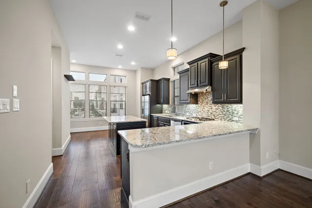 a kitchen with stainless steel appliances granite countertop a sink stove and wooden floor